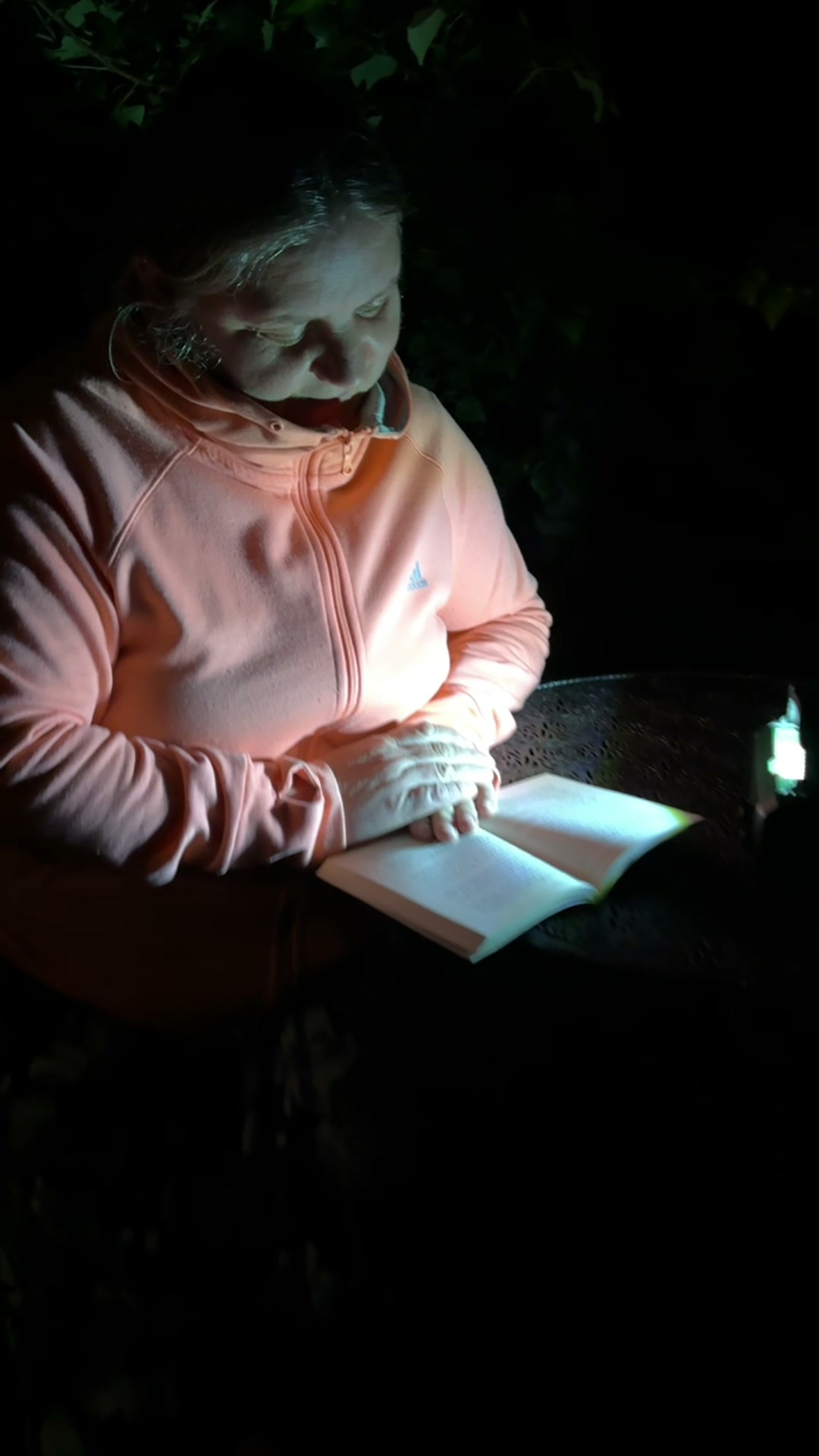 Klientka czyta przy lampie Bezpiecznego Radia nocą — nagranie 2